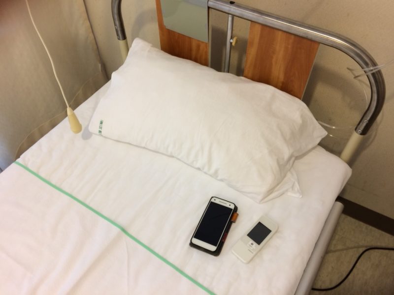 スマホとレンタルWi-Fiが乗った病院のベッド